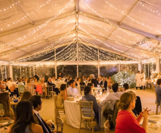 Photo of the interior of a clear wedding multistandard tent with lighting.