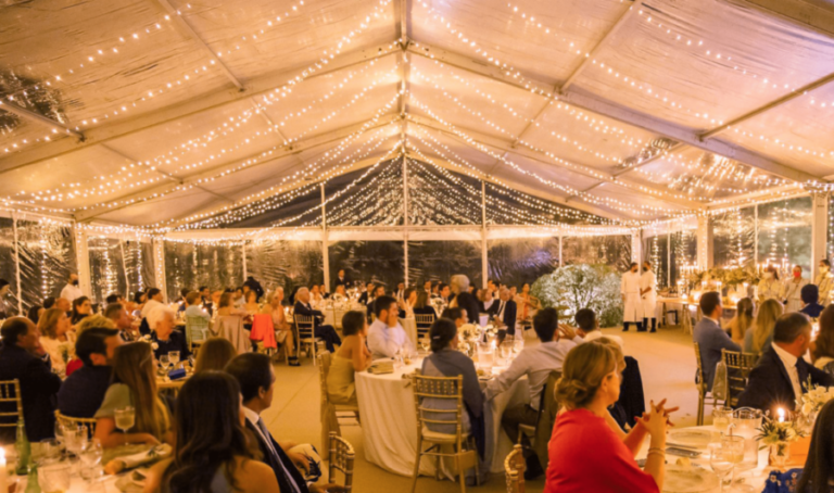 Interior de carpa a dos aguas para boda con luces decorativas