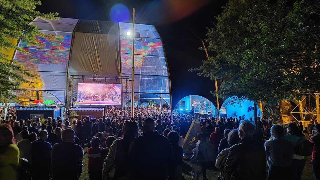 Fotografía de carpa iglú orbital con tapas blancas y transparentes alternadas y escenario principal para el evento Agitágueda 2023.