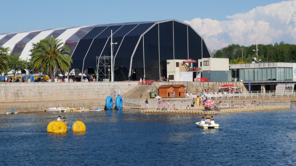 Photograph of orbital igloo tent with alternating white and transparent tops and main stage for the Agitágueda 2023 event.